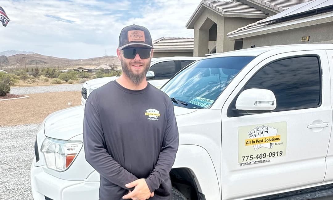 An All In Pest Solutions technician beside a company service truck in Pahrump