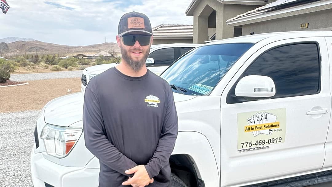 An All In Pest Solutions technician treating the exterior foundation line of a Pahrump home